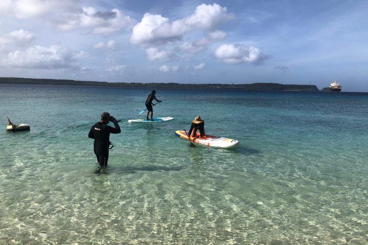 a group of people standing next to a body of water